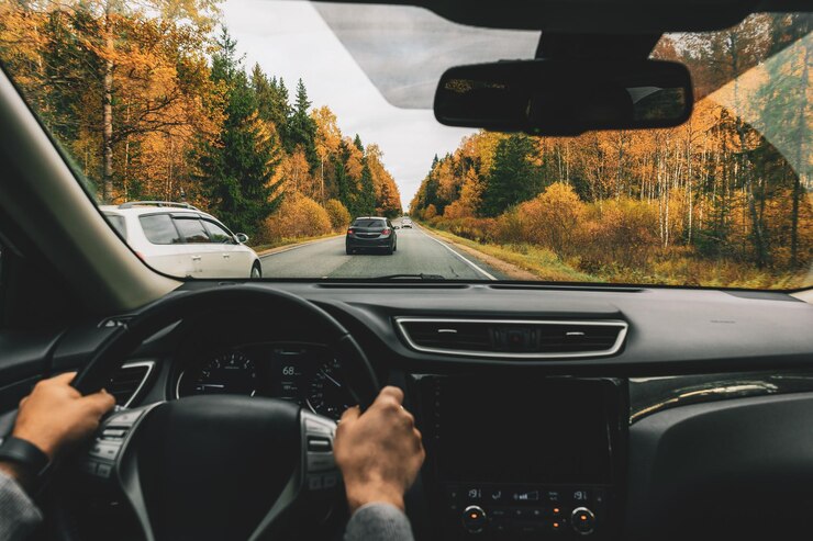 Foto homem dirigindo carro na estrada rural no outono