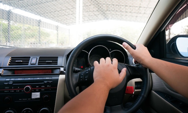 Homem dirigindo com as duas mãos no volante foco seletivo segurança dirigindo carro
