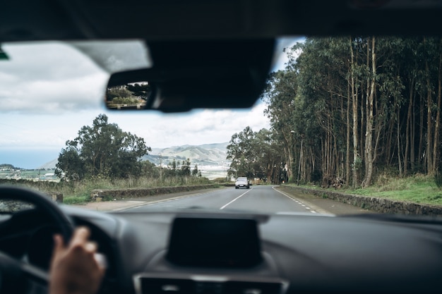 Homem dirigindo o carro com vista de dentro.