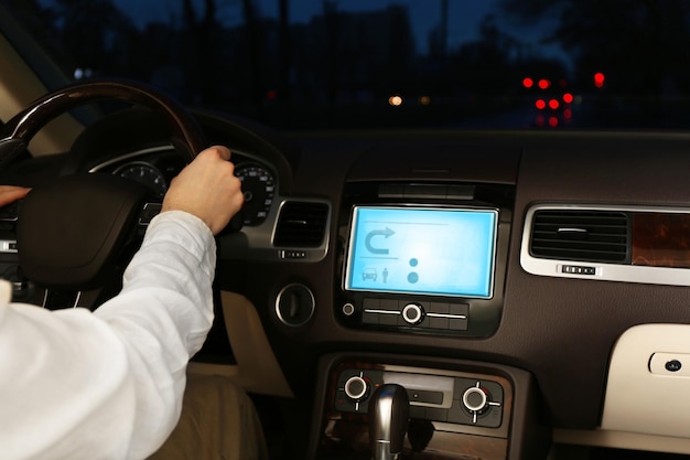 Homem dirigindo seu carro moderno à noite na cidade fechada