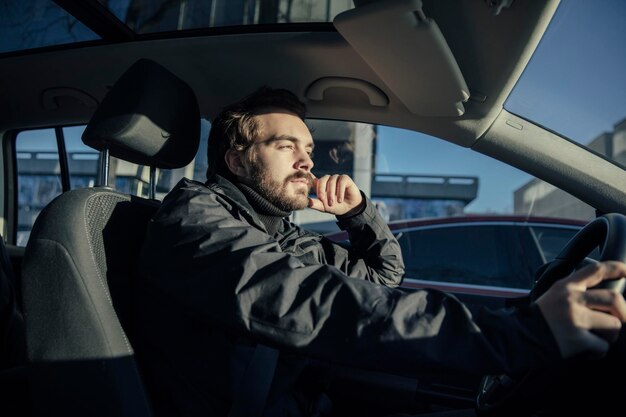 Homem dirigindo um carro com sol brilhando em seu rosto