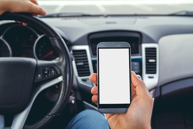 Homem dirigindo um carro com um telefone na mão