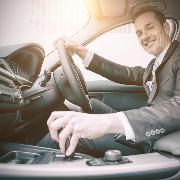 Homem dirigindo um carro e sorrindo para a câmera