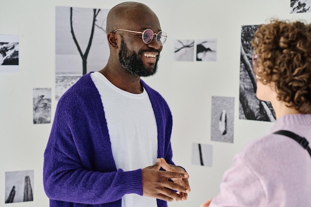 Homem discutindo arte com mulher na galeria