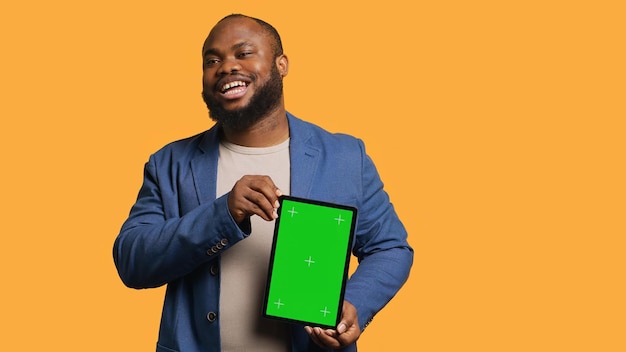 Homem divertido rindo enquanto apresenta um tablet com tela verde