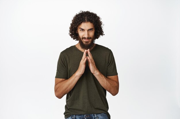 Homem do Oriente Médio ganancioso e desonesto, tramando o plano dos dedos do campanário, como a ideia do gênio do mal em mente, sobre o fundo branco