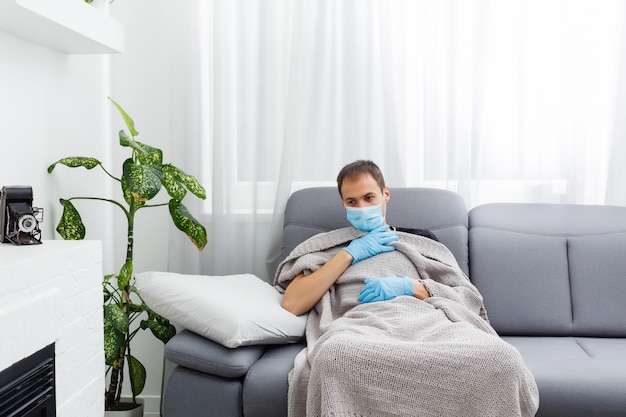 homem doente com máscara e luvas está na cama em casa