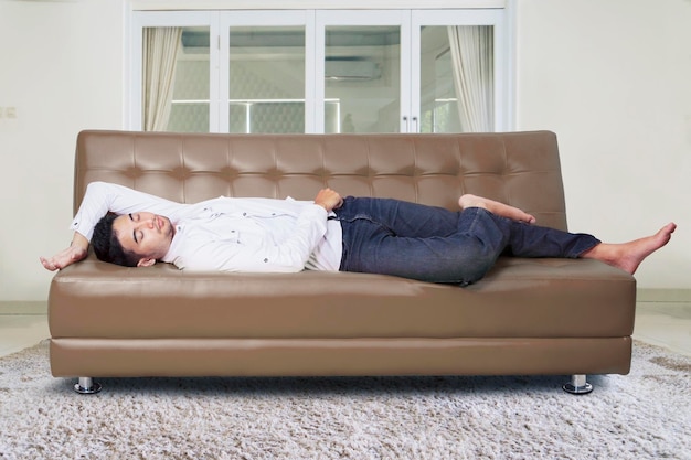 Foto homem dormindo no sofá da sala