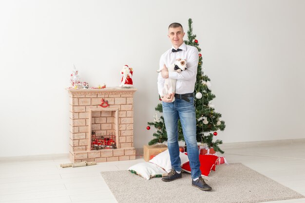 Homem e cachorro felizes em casa com a árvore de Natal