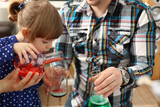 Homem e menina brincando com líquidos coloridos