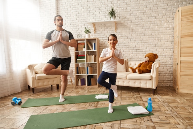 Homem e menina estão tendo o treinamento de fitness em casa.