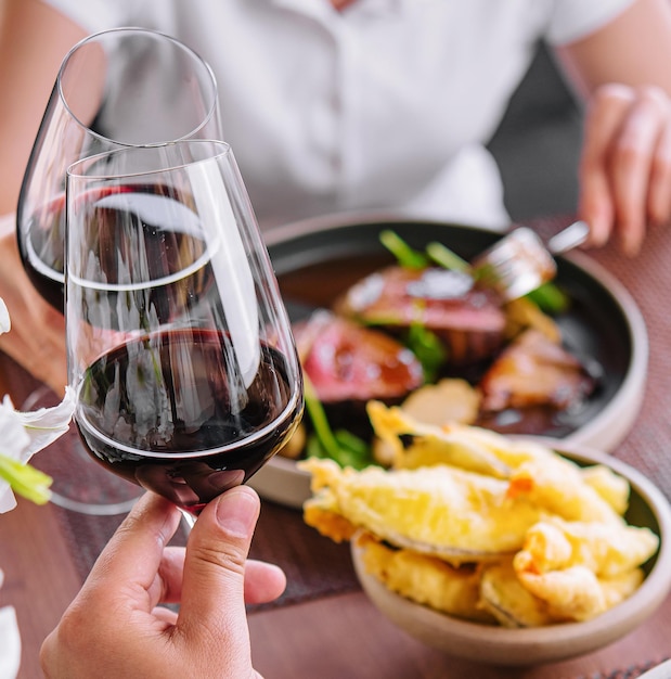 Homem e mulher a beber vinho vermelho no restaurante.