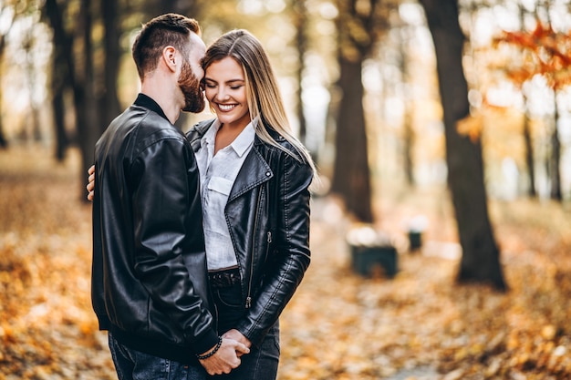 Homem e mulher, abraçando e sorrindo no fundo do parque outono.