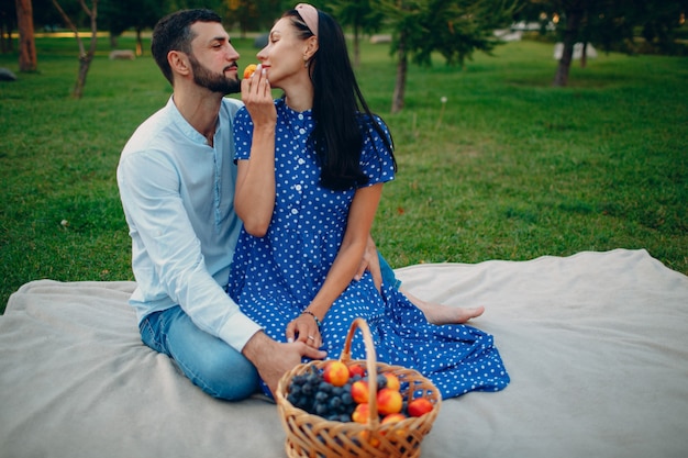 Homem e mulher adulta jovem casal piquenique sentado no prado de grama verde no parque.