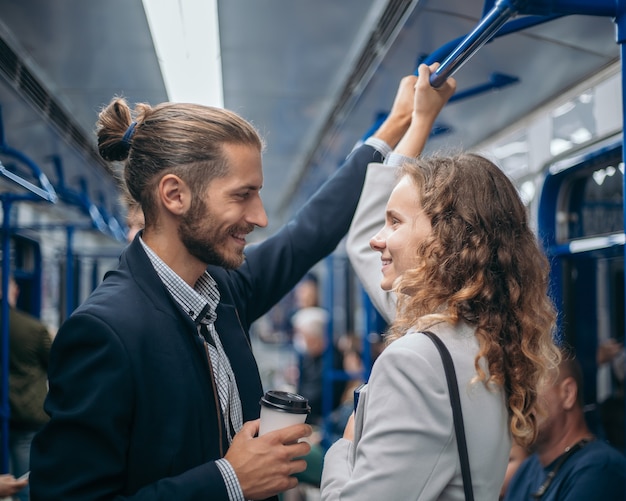 Homem e mulher apaixonados olhando um para o outro em um trem do metrô