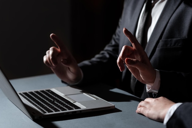 Homem e mulher, apontando com os dedos em mensagens importantes, sentado na mesa com a equipe de negócios de lap top apresentando informações cruciais com executivos de mãos mostrando dados