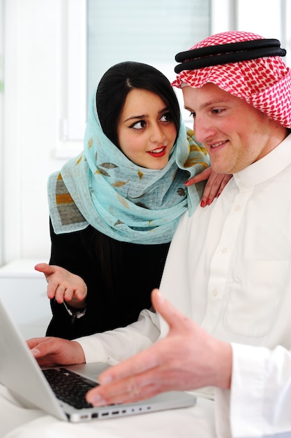 Homem e mulher árabe com laptop