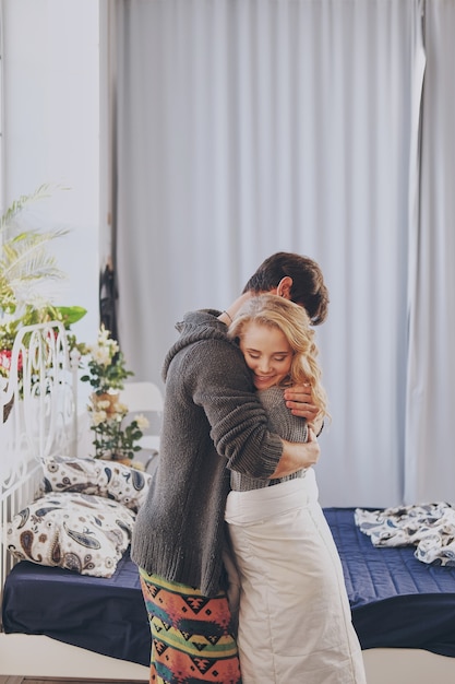 Foto homem e mulher atraentes no quarto juntos abraçando fofos