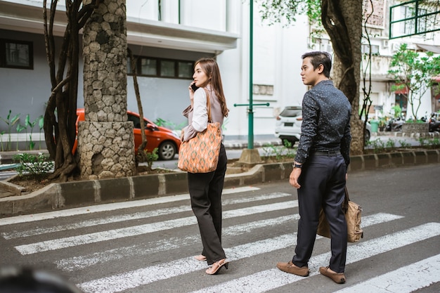 Homem e mulher caminham atravessando a rua