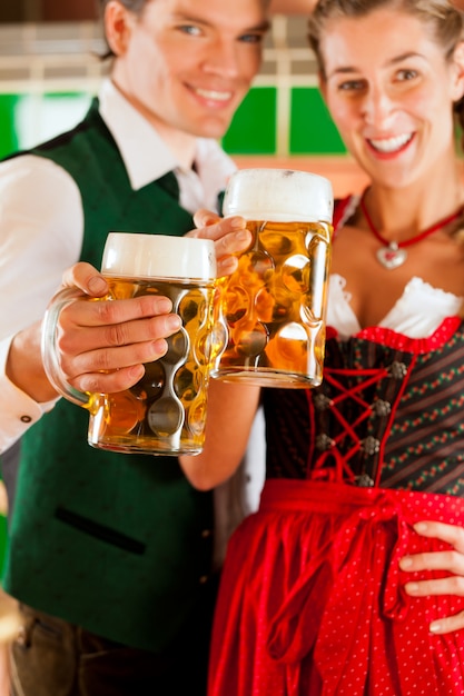Homem e mulher com copo de cerveja na cervejaria