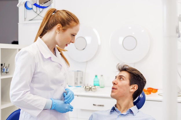 Homem e mulher conversando no consultório do dentista