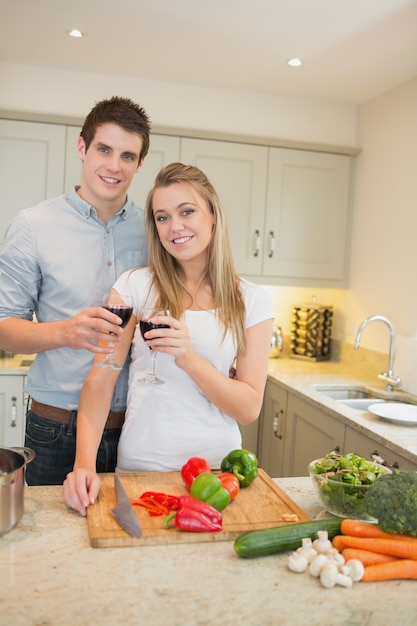 Homem e mulher cozinhando e batendo copos de vinho