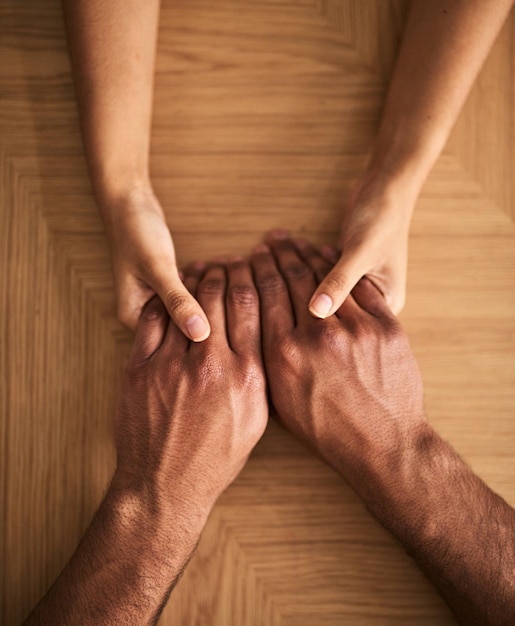 Foto homem e mulher de mãos dadas compartilhando sentimentos de apoio amoroso e confiança juntos em uma mesa close de um casal amoroso expressando promessa de cuidado e compaixão para superar problemas