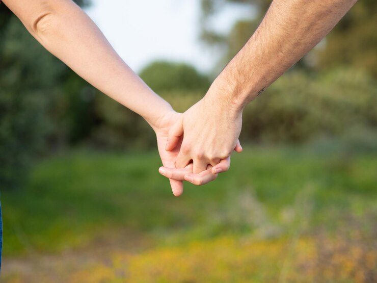 Foto homem e mulher de mãos dadas juntos no fundo desfocado natural