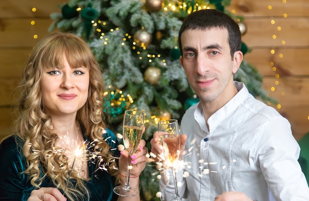 Homem e mulher de Natal com taças de champanhe. Foco seletivo. Feriado.