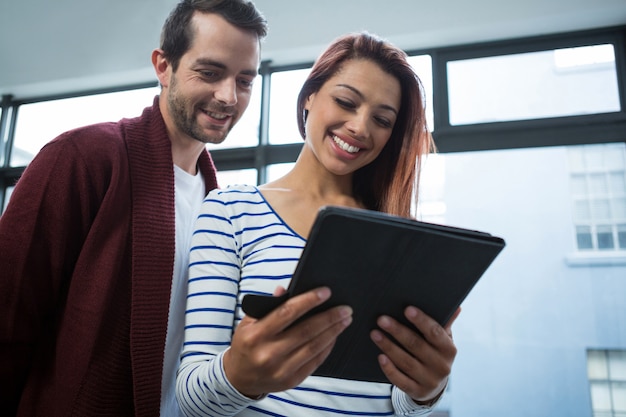 Homem e mulher discutindo sobre tablet digital