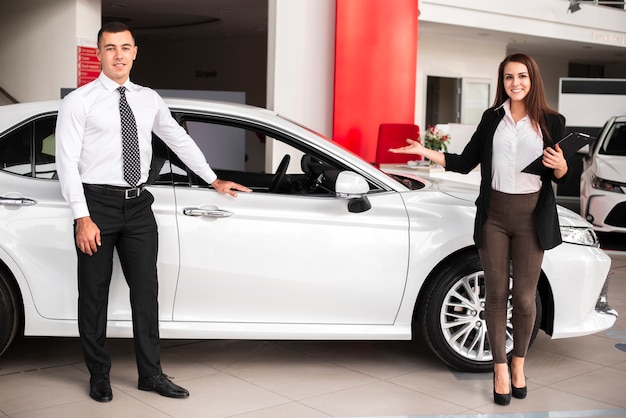 Foto homem e mulher em uma concessionária de carros