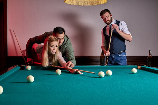 Homem e mulher estão jogando bilhar, um cara está ensinando uma mulher a jogar bilhar. entretenimento, conceito de férias