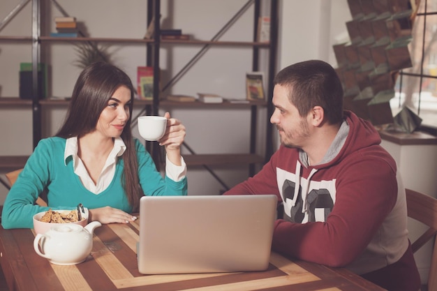 Homem e mulher estão sentados à mesa