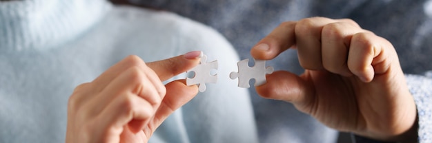Homem e mulher estão tentando conectar quebra-cabeças brancos