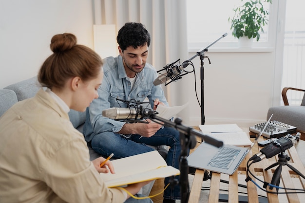 Homem e mulher executando um podcast juntos no estúdio