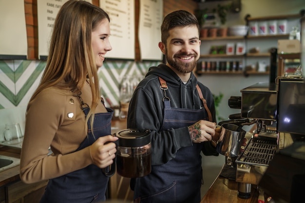 Homem e mulher fazendo café em um café