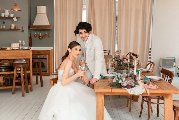 Foto homem e mulher filmam com decoração beijos abraços casal feliz amantes noiva e noivo em decoração de luxo noiva e noivo juntos casal abraçando recém-casados no dia do casamento