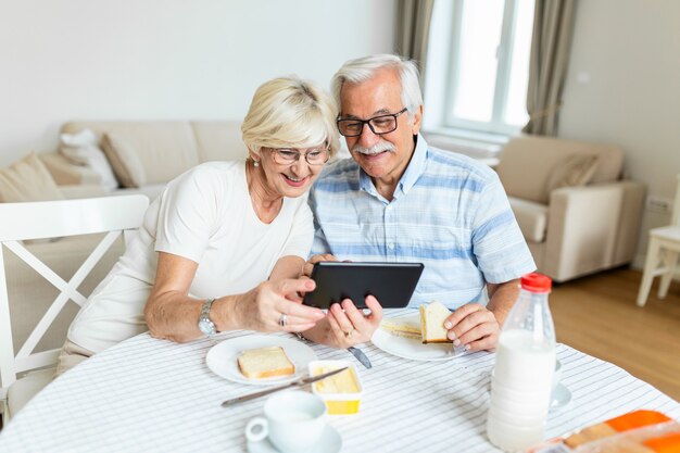 Homem e mulher maduros e aposentados usando tablet digital