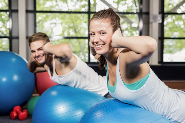 Homem e mulher malhando na bola de fitness