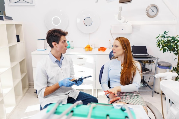 Homem e mulher no consultório do dentista moderno