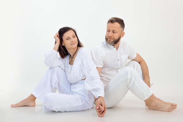 Homem e mulher no estúdio filmado casal em roupa branca de mãos dadas juntos tratamento de psicologia para