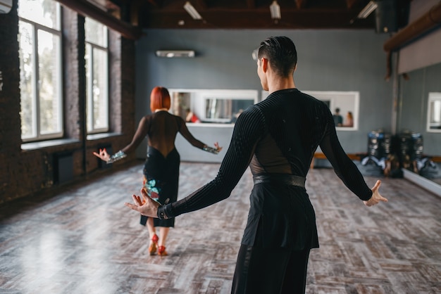 Homem e mulher no treinamento de dança ballrom em classe. Parceiros masculinos e femininos em pares profissionais dançando no estúdio