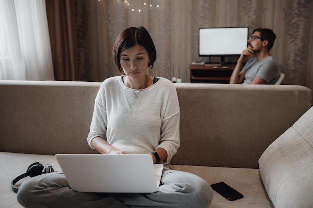 Homem e mulher ocupados estudando muito com laptop no prazo na sala de estar em casa