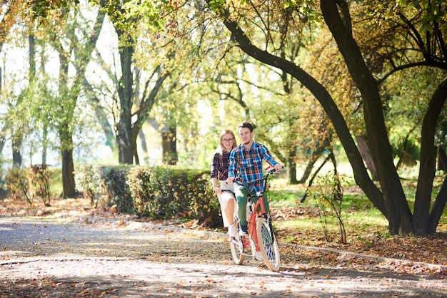 Homem e mulher pedalando juntos em bicicleta dupla tandem