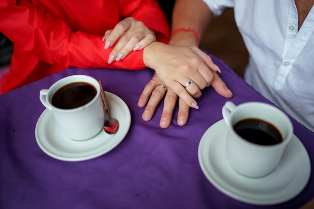 Homem e mulher recém-casados de mãos dadas com fundo borrado em close-up