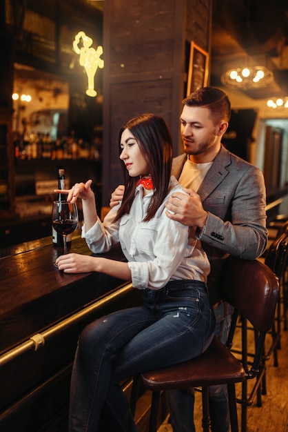 Homem e mulher relaxam, casal no balcão de madeira