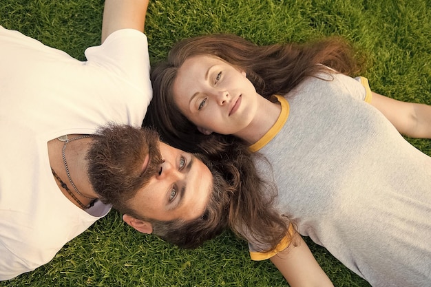 Homem e mulher relaxam o conceito de sonho ao ar livre Conceito de namoro brutal homem e menina despreocupados Juventude e liberdade Mais perto da natureza casal sinta-se livre casal deite-se na grama verde Relaxe na grama da primavera