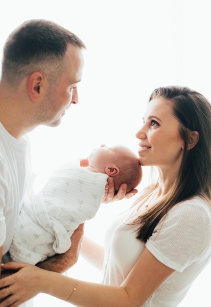 Homem e mulher segurando um bebê recém-nascido