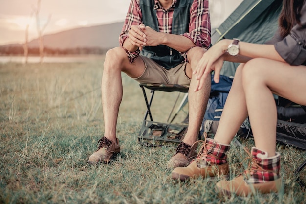 Homem e mulher sentados em cadeiras no acampamento.