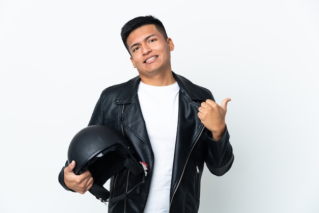 Homem ecudoriano com capacete de motociclista isolado em parede branca apontando para o lado para apresentar um produto
